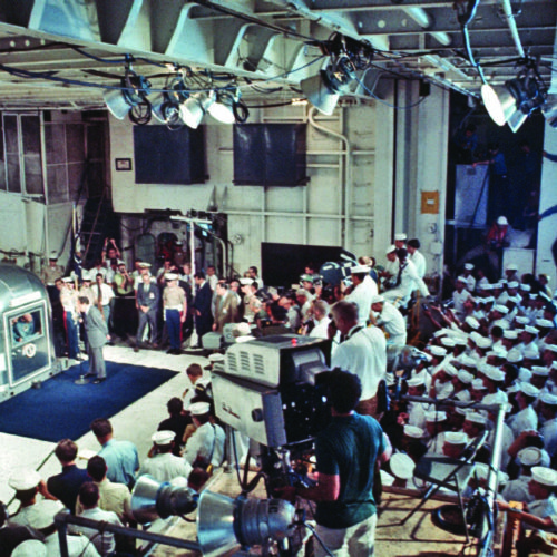 Sailors watch behind the press as Nixon addresses the Apollo 11 astronauts.