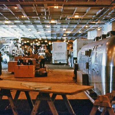 This photo shows both vans (see above) chained down in front of the secondary Mobile Quarantine Facility (MQF) in Hangar Bay 1. The HS-4 astronaut recovery Sea King helo # 66 is sitting next to them with helo #64 by the port side elevator—it was an Underwater Demolition Team (UDT) helo.