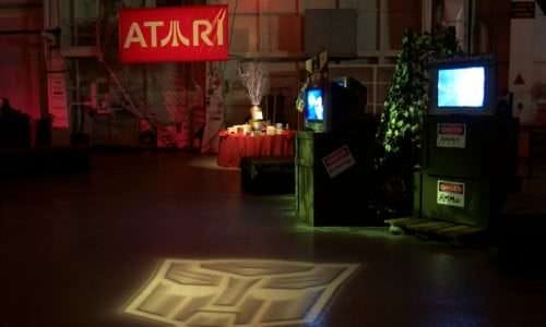 Event setup with Atari banner, video screens, and decorations.