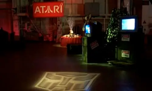 Event setup with Atari banner, video screens, and decorations.
