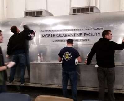 Volunteers cleaning NASA Mobile Quarantine Facility at museum.