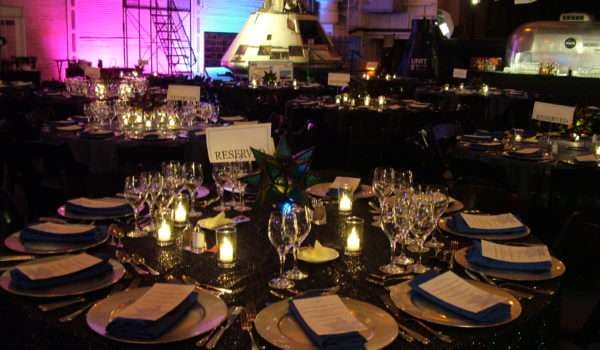 Elegant dinner table setup with candles and glassware at gala.