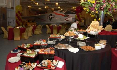 Buffet setup with assorted dishes and aircraft in background.