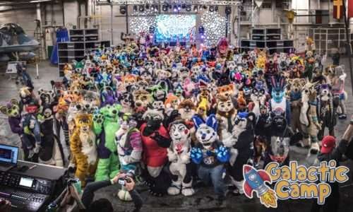 Large group of people in colorful costumes at Galactic Camp event.