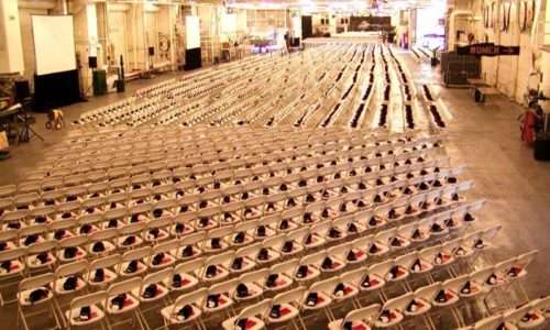 Rows of chairs with hats set up for a ceremony.