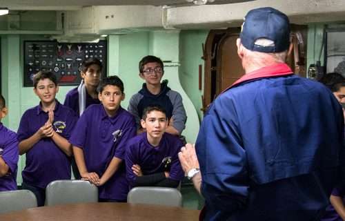 Guide speaking to students in USS Hornet's interior.