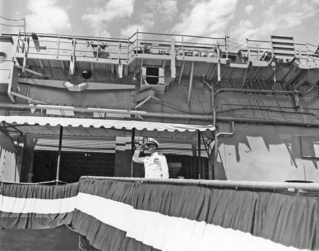 Man in uniform saluting from a ship