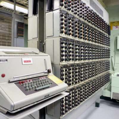 Vintage computer system with control panels and typewriter-style console.