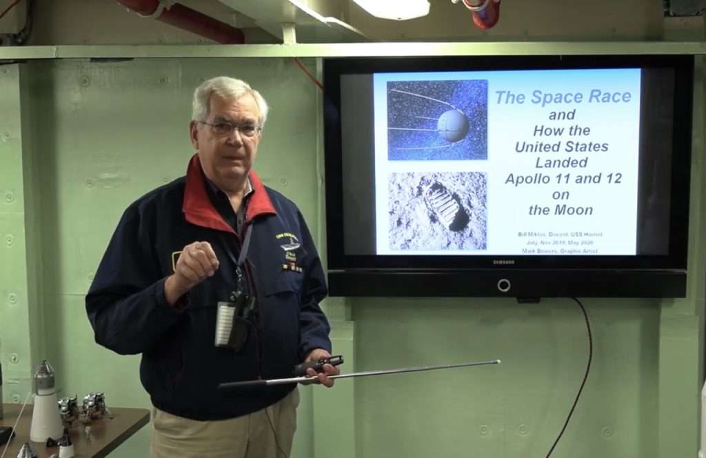 Man presenting an educational slideshow on a TV screen