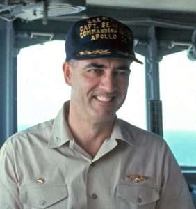 Captain C.J. Seiberlich wearing USS Hornet Apollo 11 commanding officer hat, smiling.