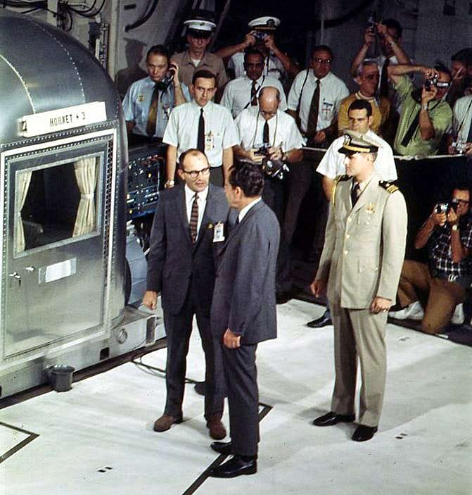 President Nixon and Dr. William Carpentier speak near the Hornet-3 mobile quarantine facility, surrounded by military and press.