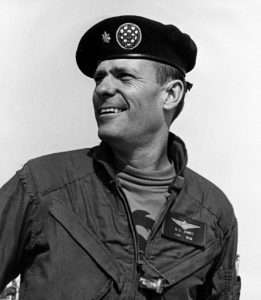 Helicopter pilot Don Jones in flight suit and beret smiling on USS Hornet.