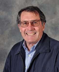 Clancy Hatleberg in blue jacket and glasses smiling