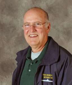 Bruce Johnson, USS Hornet Museum volunteer, in a navy jacket and glasses.