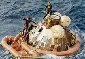 Navy divers recover Apollo 11 Command Module in the ocean.