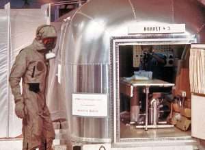 Technician in quarantine suit outside Apollo 11 mobile quarantine facility