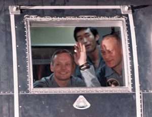 Astronauts waving from quarantine unit after Apollo 11 mission.