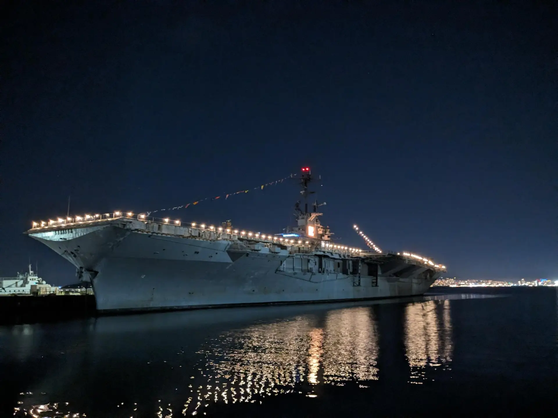 Picture of USS Hornet at night with lights on.