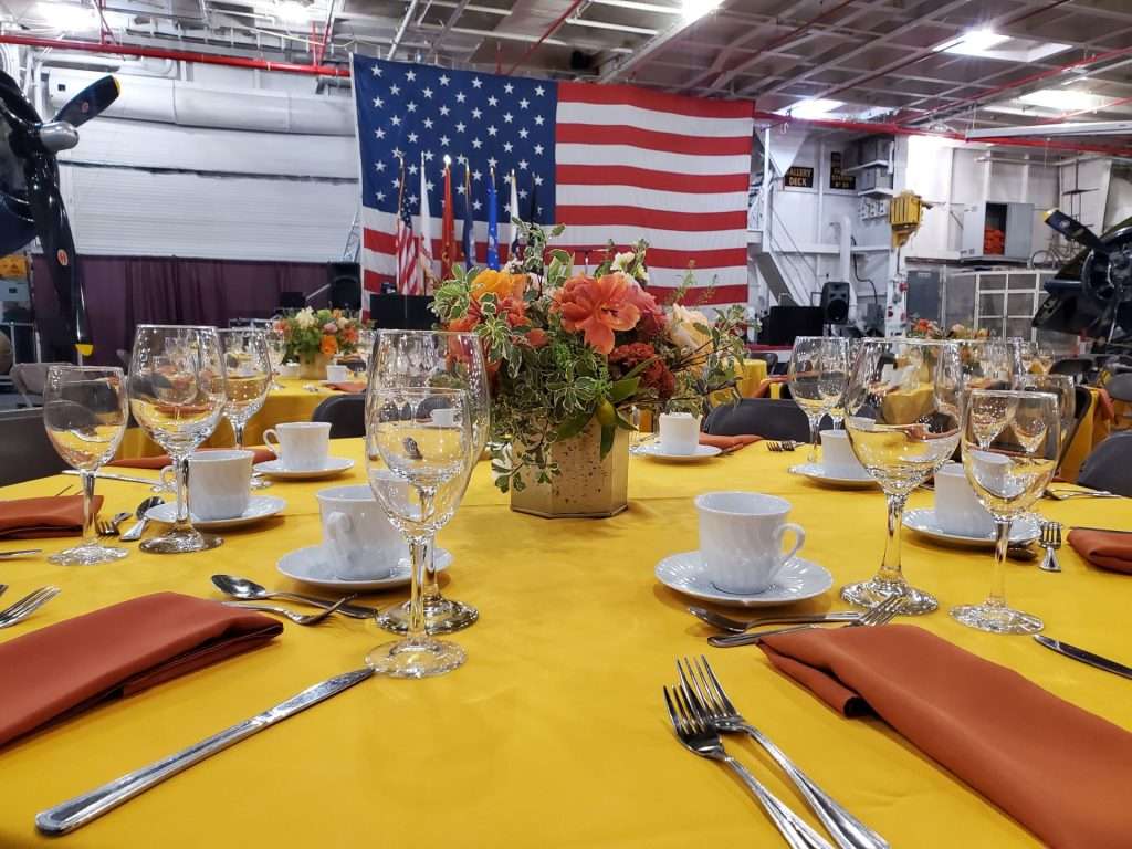 Table set for a special event with a yellow tablecloth